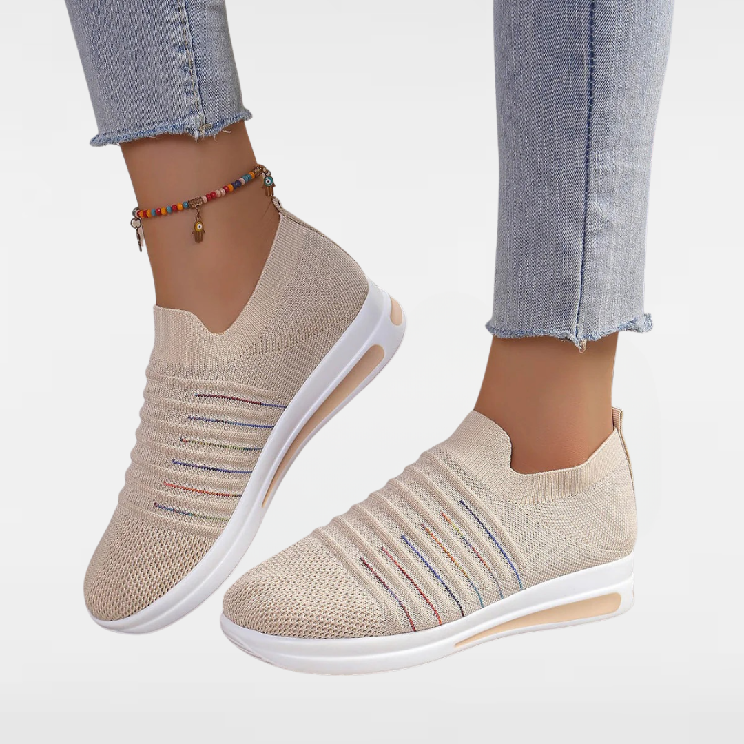 Beige knit slip-on sneakers with V-cut collar, multicolor stripe detail, and white sole