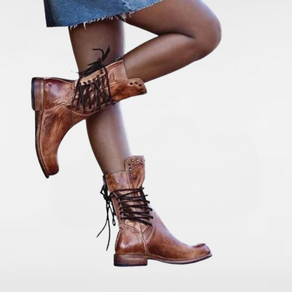 Brown vintage leather lace-up boots with studded ankle panels and low heel.