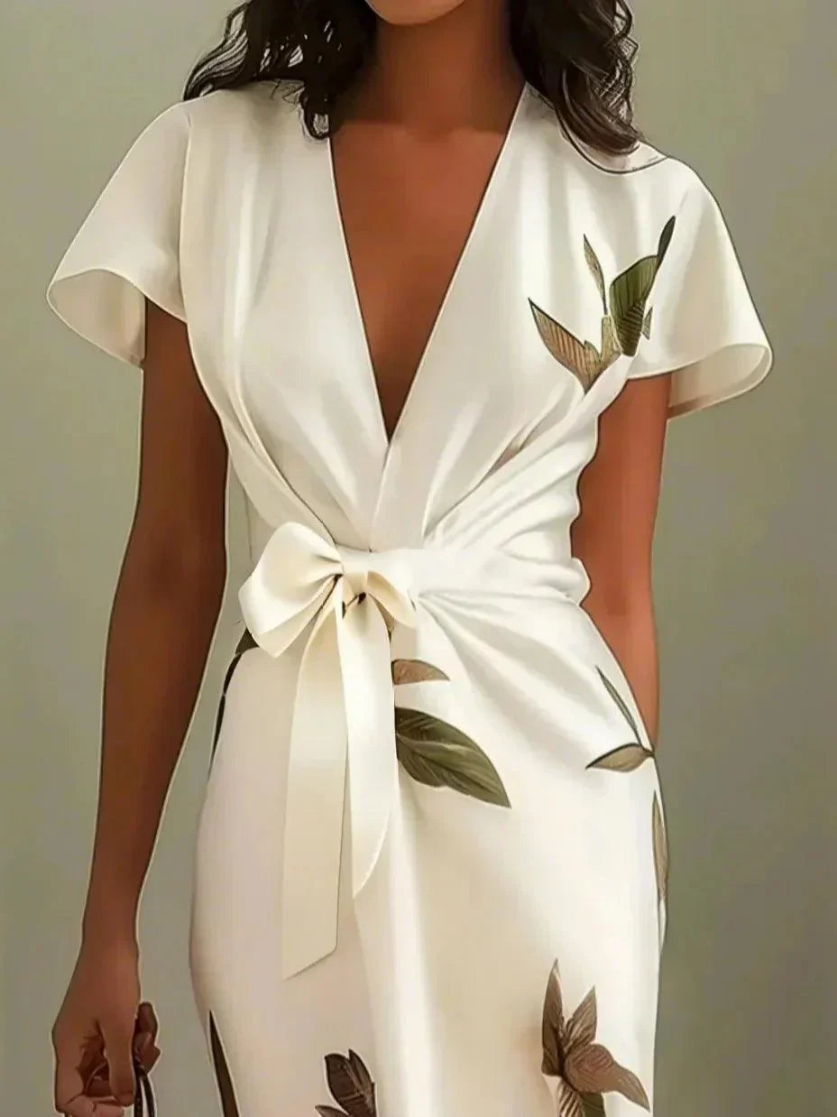 White wrap midi dress with V-neck and short sleeves, leaf print, and bow tie waist