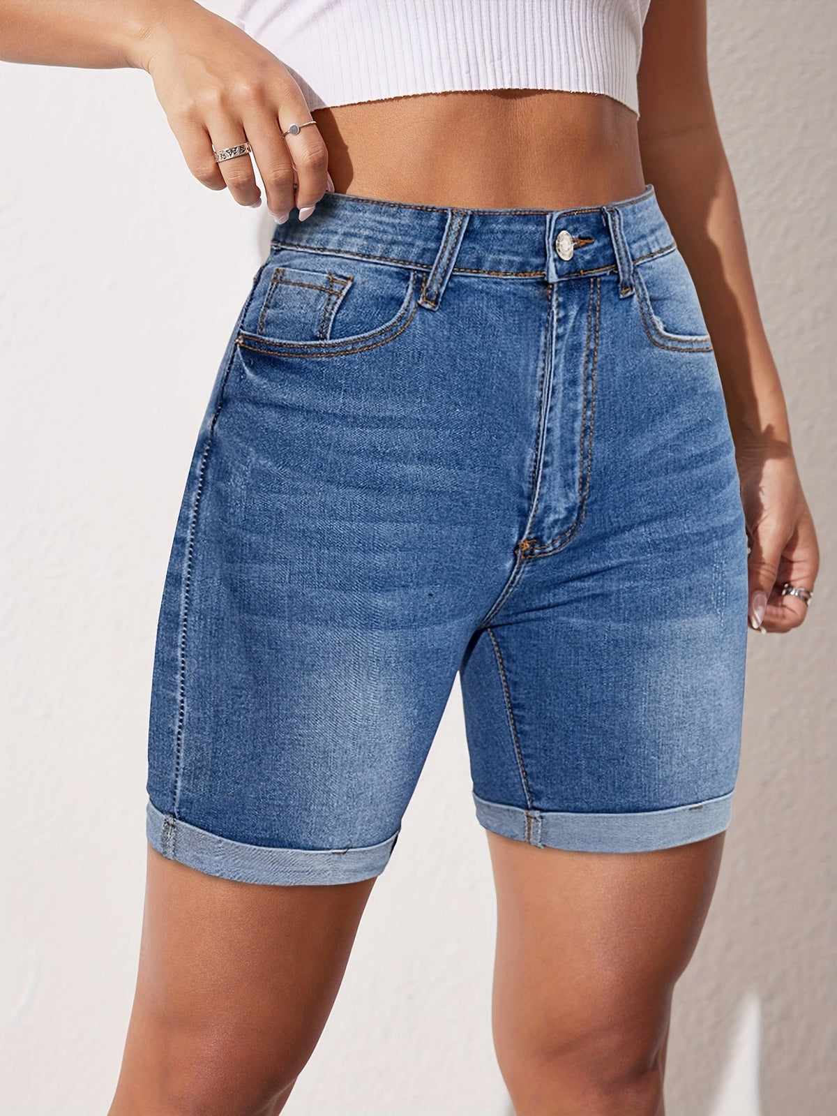 Light blue denim bermuda shorts with front pockets, belt loops, and button closure