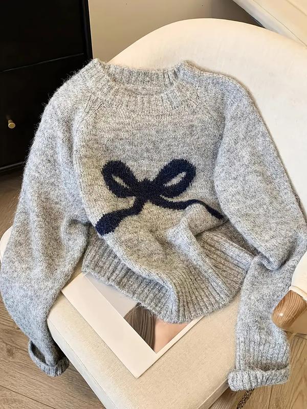 Grey knit sweater with ribbed crew neck, cuffs, and large navy bow intarsia