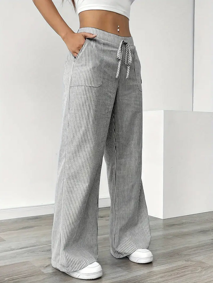 Striped wide-leg pants with drawstring and side pocket detail, black-and-white vertical stripes
