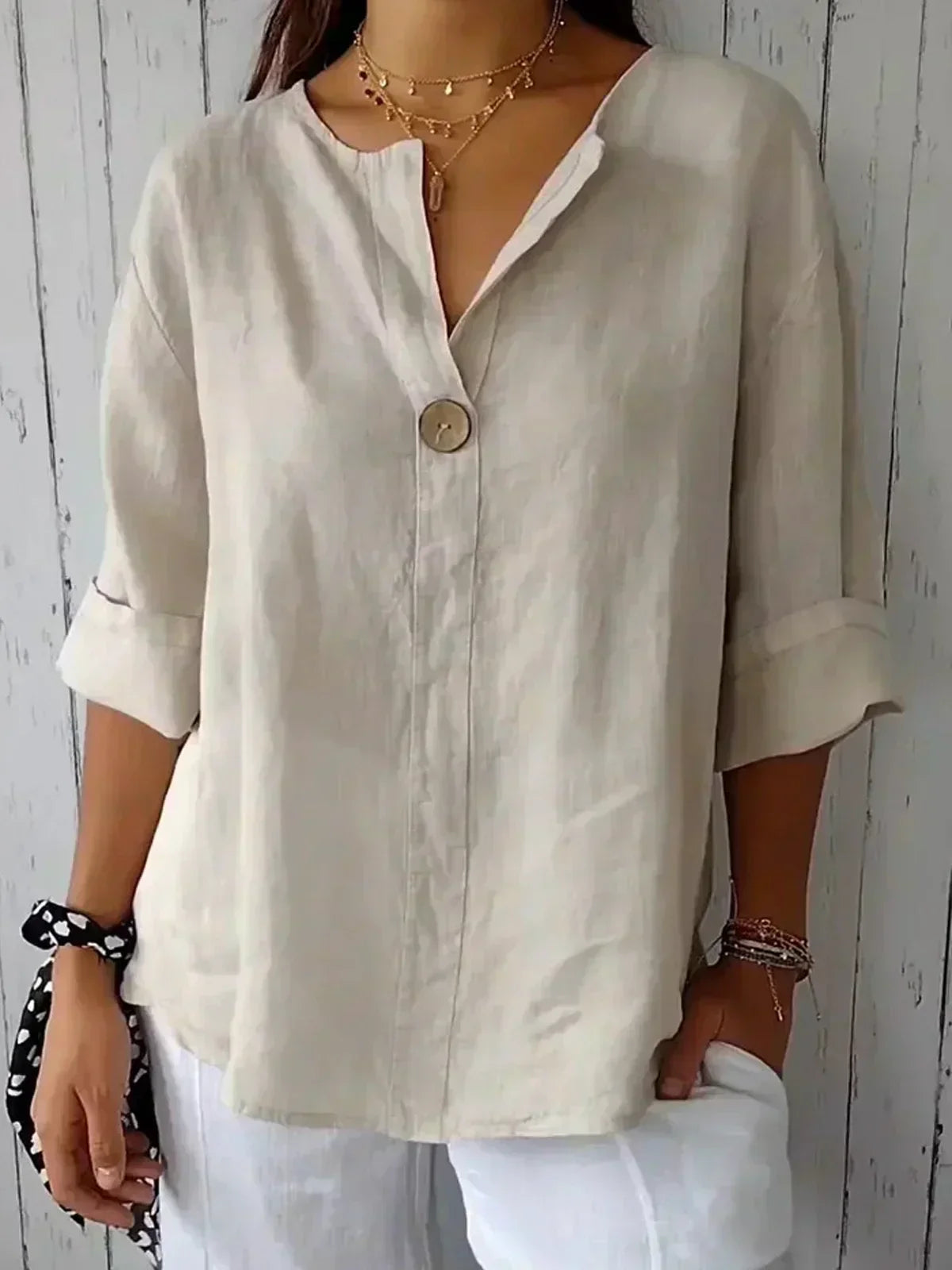 Light beige women’s V-neck blouse with button front and elbow-length sleeves
