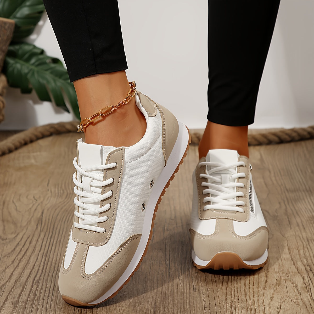 Casual low-top sneakers, cream white with beige accents, lace-up and ankle chain.