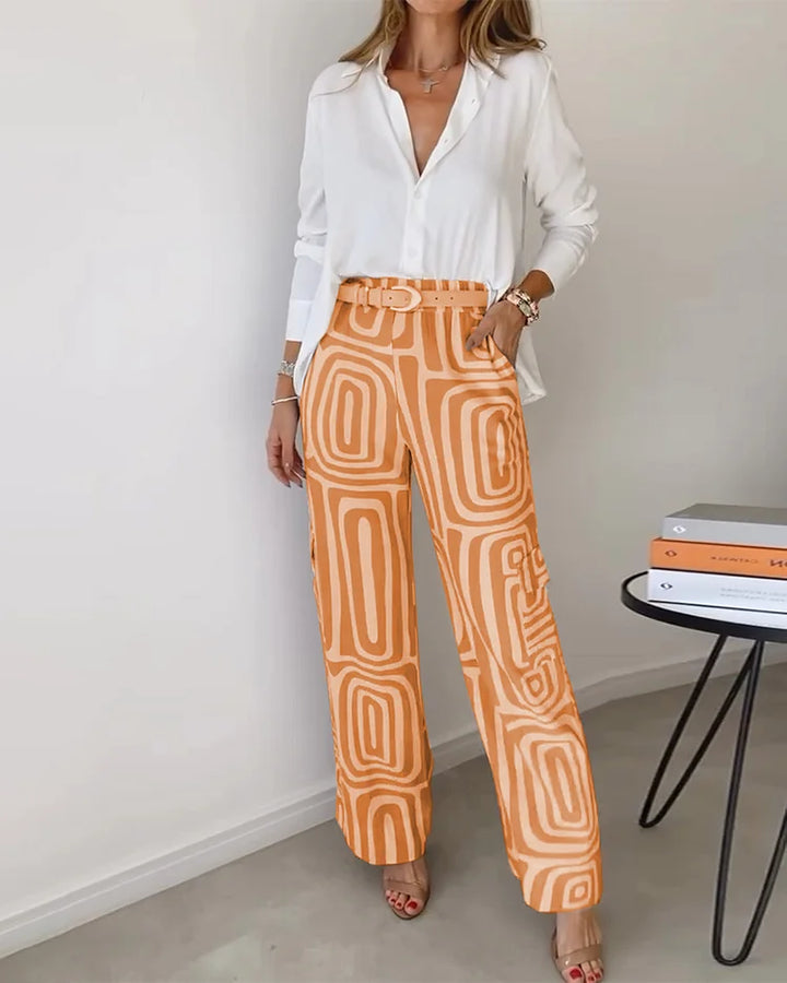 Two-piece set with white button-front blouse and orange abstract-pattern trousers with belt