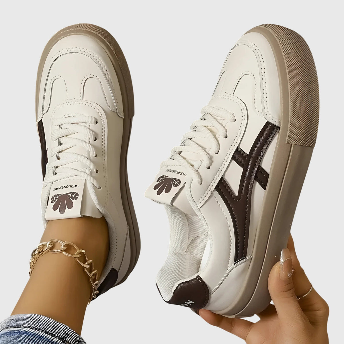 White orthopedic sneakers with dark brown side stripes and tan platform sole, front lace-up