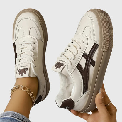 White orthopedic sneakers with dark brown side stripes and tan platform sole, front lace-up
