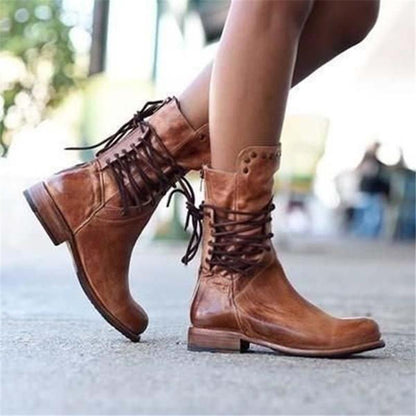 Brown leather lace-up boots with eyelet lacing, studded cuff, and flat heel.