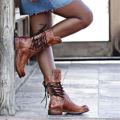 Brown leather lace-up boots with studded cuff and scuffed vintage finish.