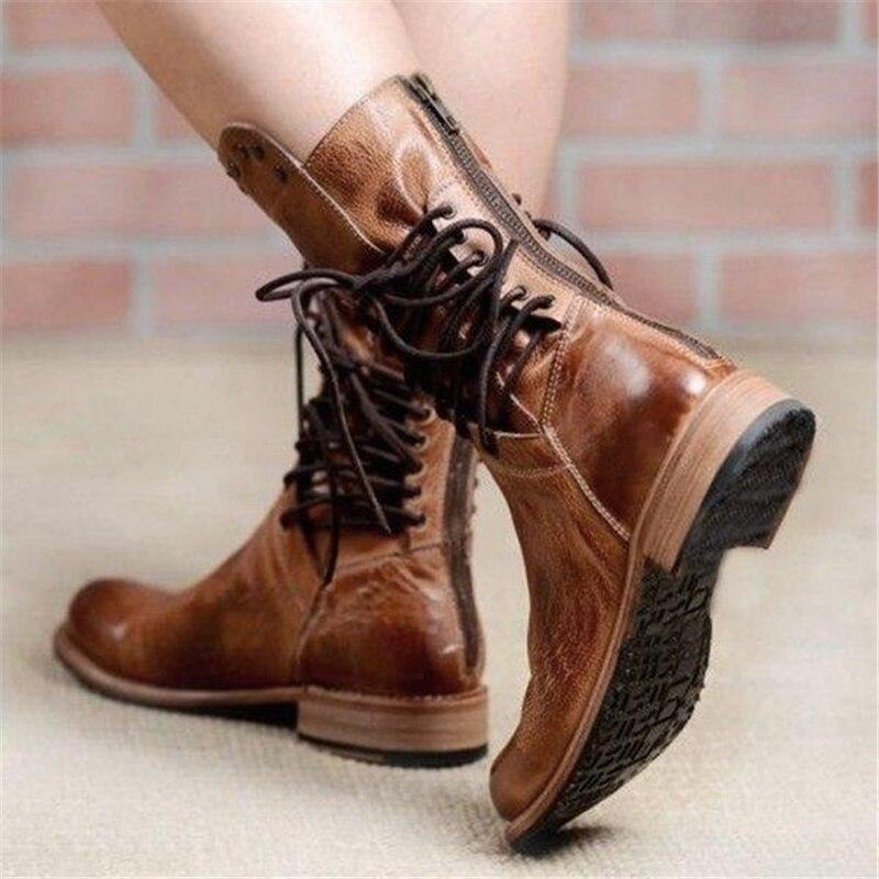 Tan-brown leather lace-up boots with studded side strap and chunky sole.