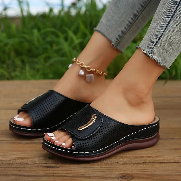 Perforated slide sandals in black with wide toe strap and cushioned sole
