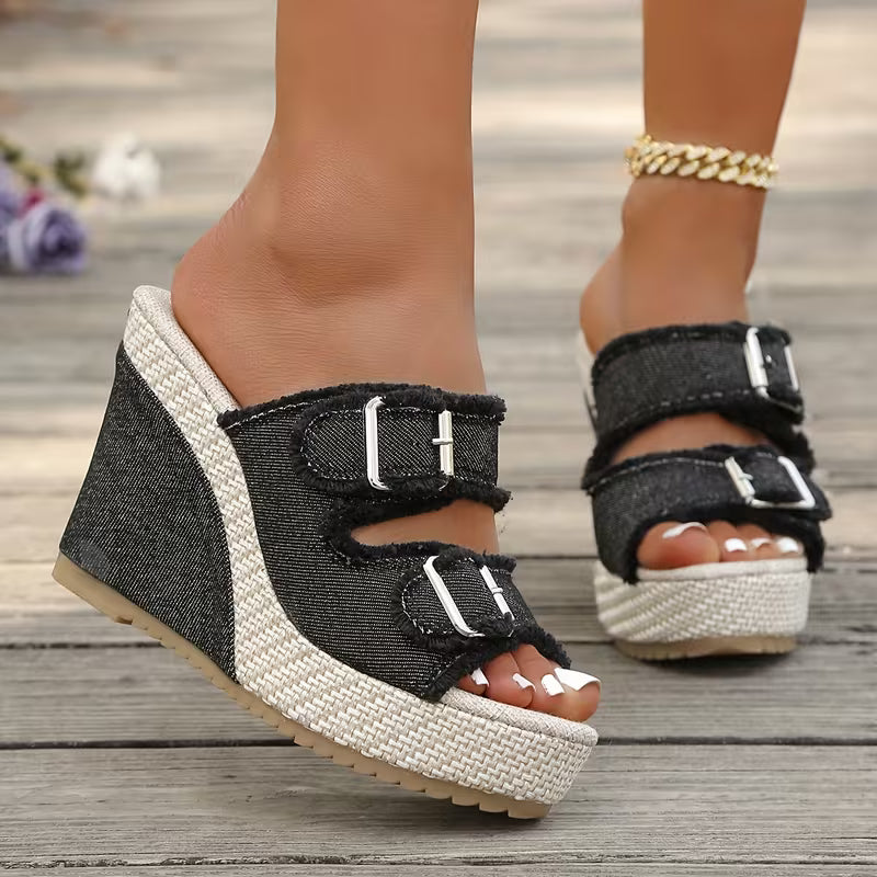 Black wedge sandals with two buckle straps and open toe, textured platform sole