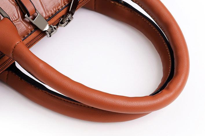 Brown croc-pattern handbag handle with stitched trim and metal attachment hardware