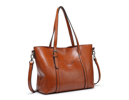 Women’s spacious crossbody tote bag in brown leather with top handles and shoulder strap