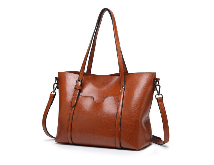 Women’s leather-look crossbody bag in brown, with top handles and adjustable strap.