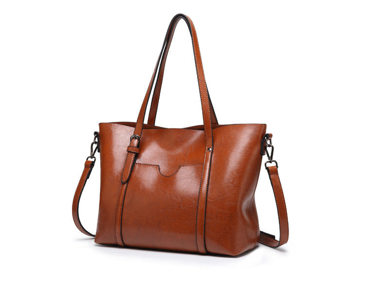 Women’s leather-look crossbody bag in brown, with top handles and adjustable strap.