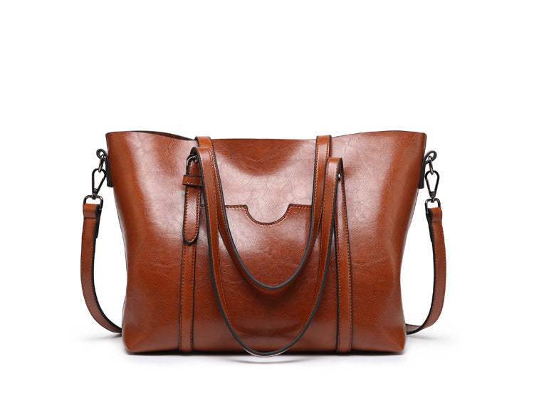 Women’s leather-look crossbody bag in brown, with wide straps and top flap.