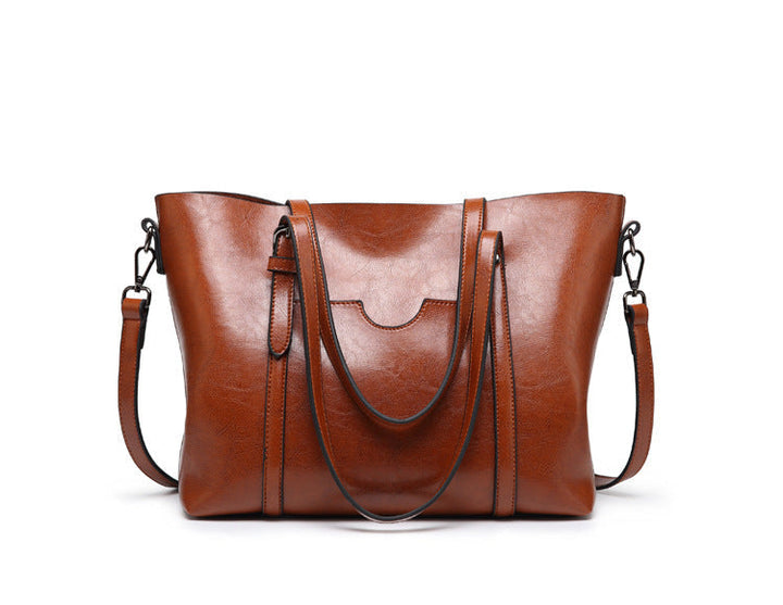 Women’s leather-look crossbody bag in brown, with wide straps and top flap.