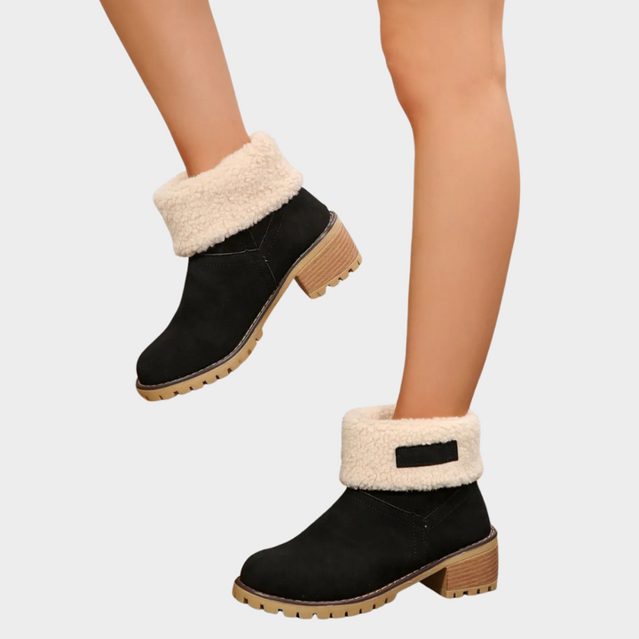 Black winter boots with sherpa cuff, tan block heel, and lug rubber sole.