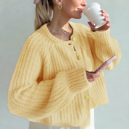 Yellow knit cardigan sweater with round neck, long sleeves, and front button placket