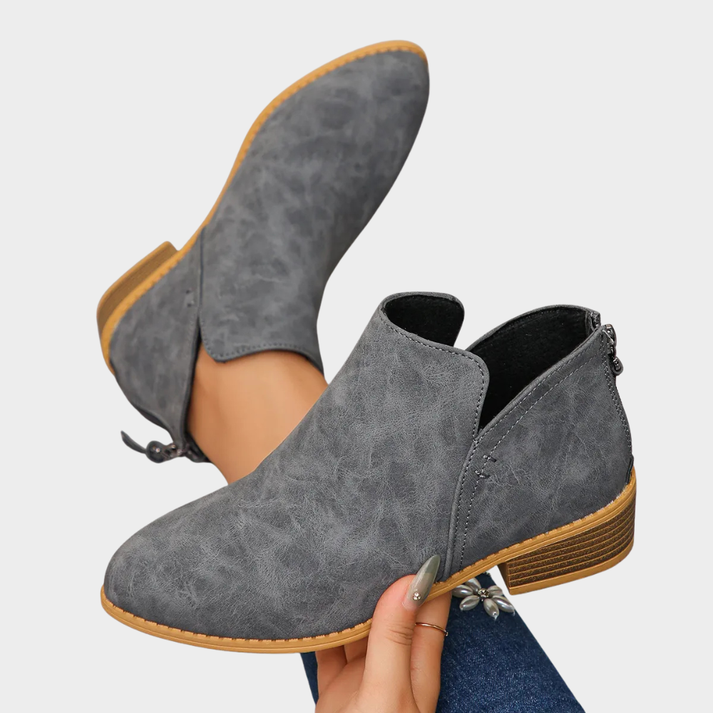 Gray suede low-heel ankle boot, side angle with tan outsole edge trim