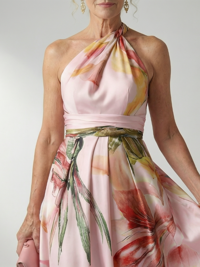 Amiel floral maxi dress close-up, halter neckline and waist belt, pink base with green and red blooms