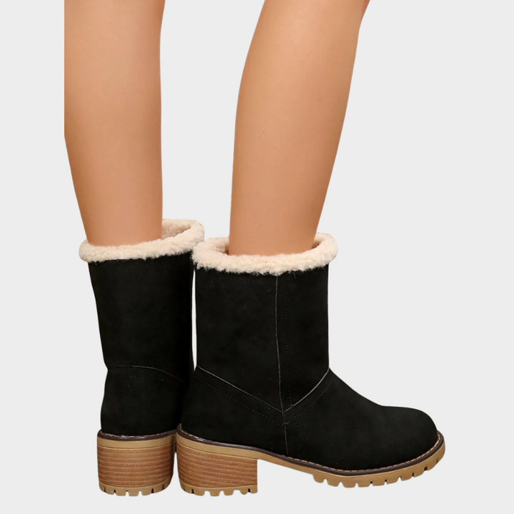 Black suede mid-heel winter boots with white sherpa lining and textured outsole