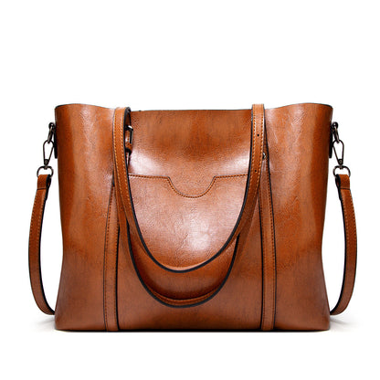 Women’s leather-look crossbody bag in brown, with two side straps and top flap.