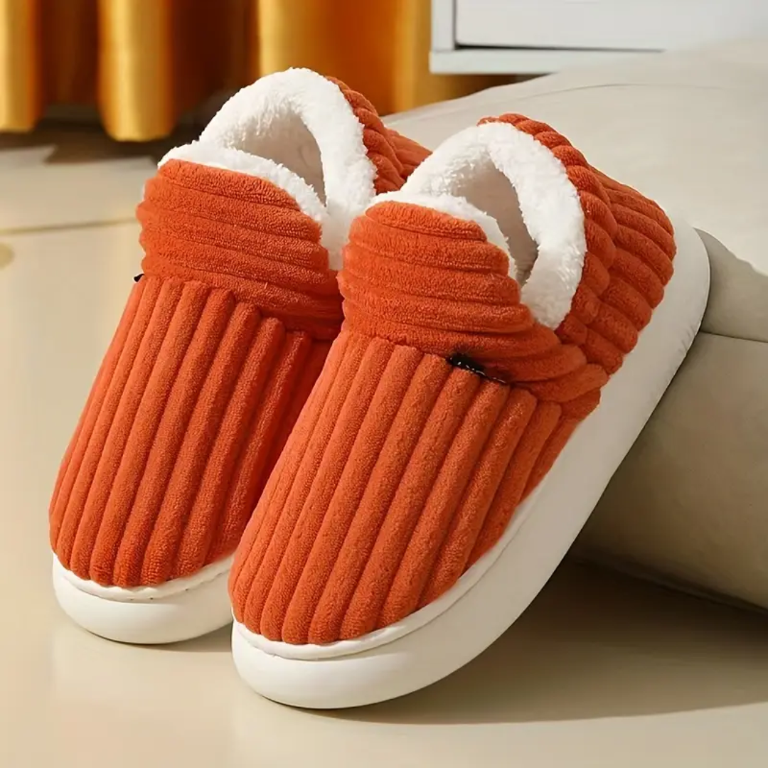 Orange comfort slippers with ribbed fabric and white fuzzy lining on white soles