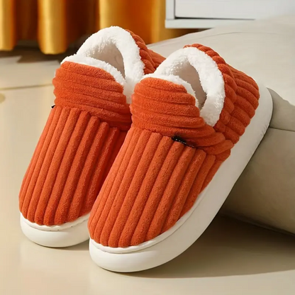 Orange comfort slippers with ribbed fabric and white fuzzy lining on white soles