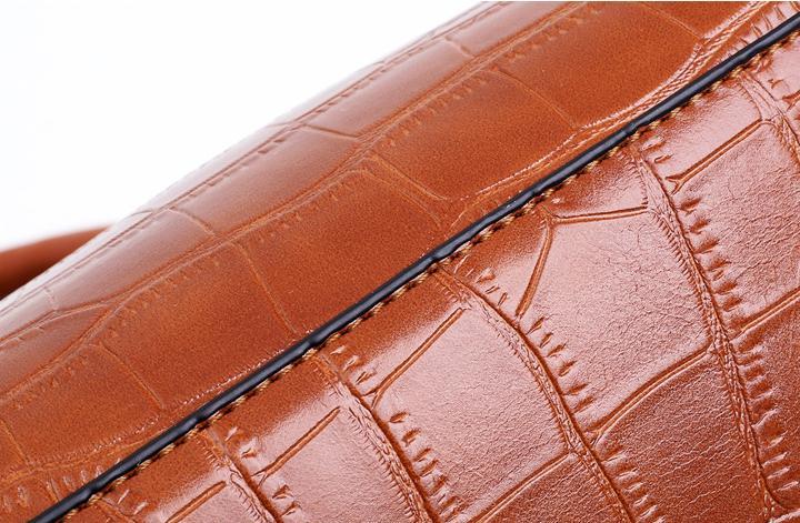 Brown croc-pattern handbag exterior with fine stitching along the strap panel