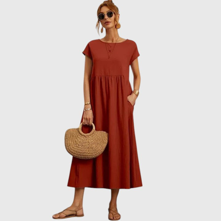 Rusty red midi dress with short sleeves and gathered waist seam; relaxed fit.