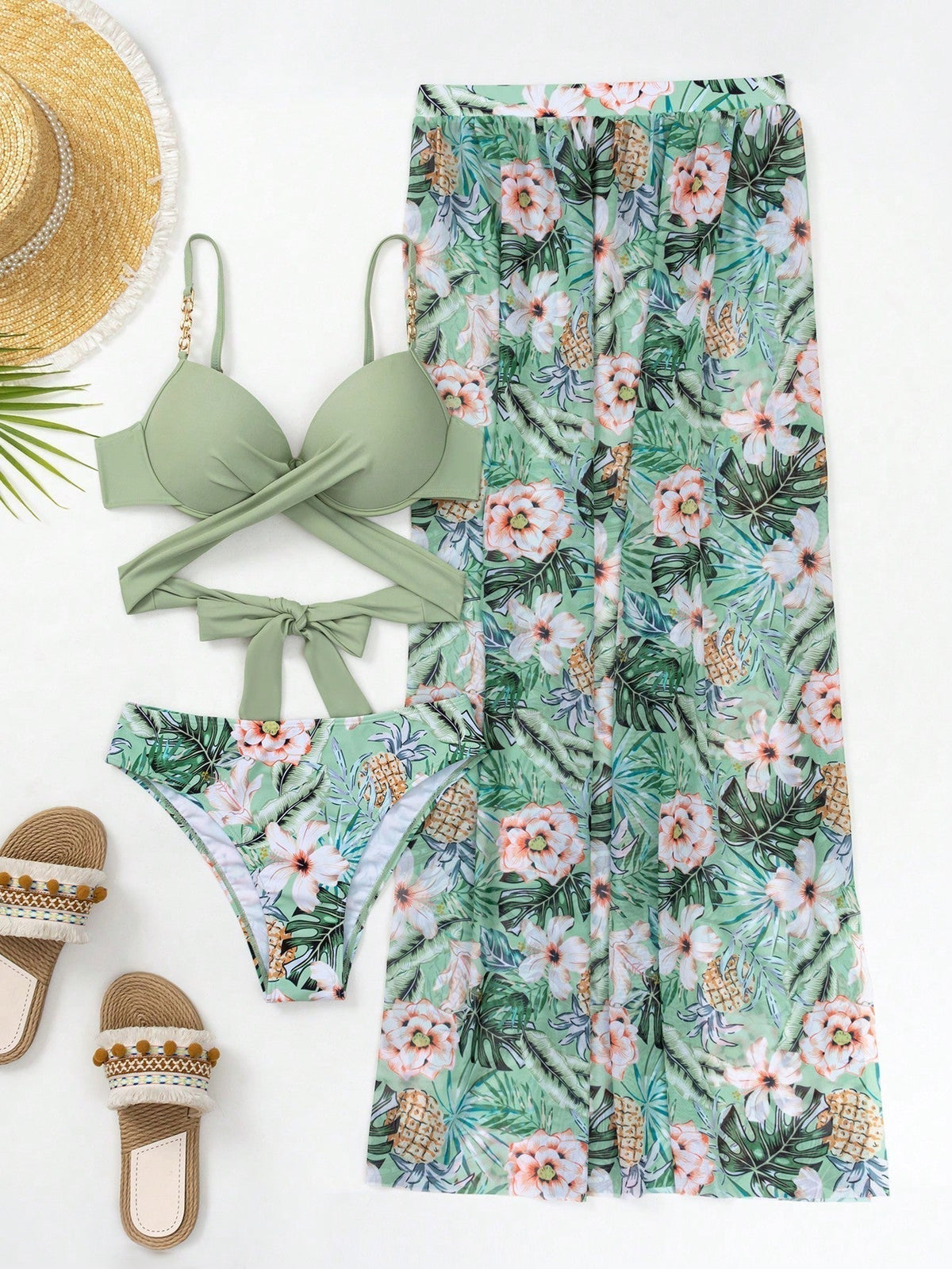 Green bikini set with floral cover-up skirt and matching bottoms, flat lay