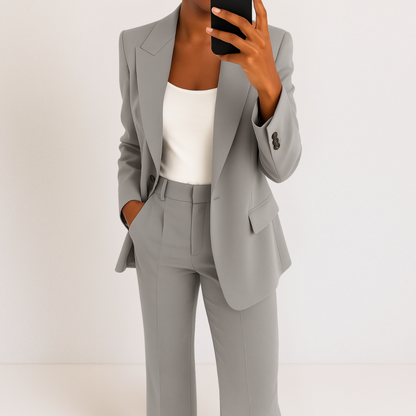 Grey two-piece suit set with tailored blazer and matching trousers, notched lapel and flap pockets.