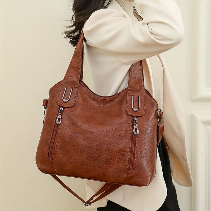 Lumi women’s tote bag in brown with two handles, top zip, and adjustable shoulder strap