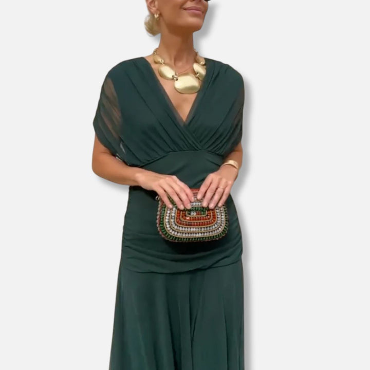 Elegant dress in deep green with V-neckline, draped bodice, and short sleeves