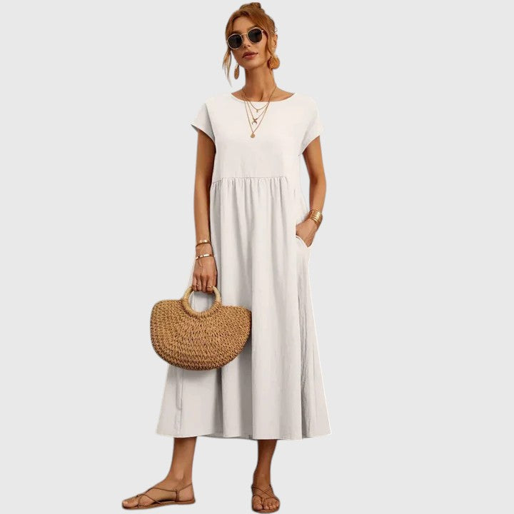 White midi dress with short sleeves and gathered waist seam; relaxed fit.