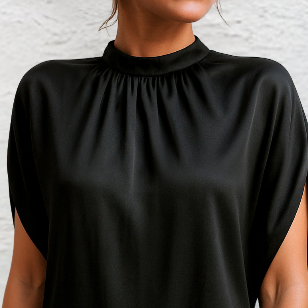 Black mini dress with high neck and gathered yoke; short cape sleeves