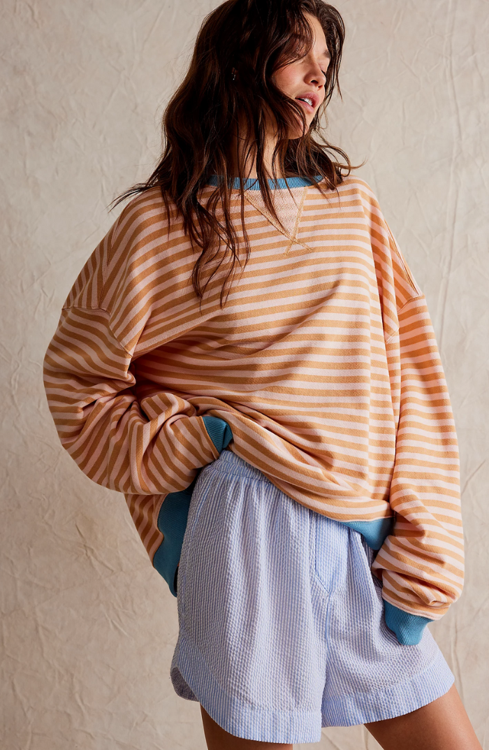 Striped sweater with tan and brown horizontal stripes, loose fit with teal ribbed cuffs