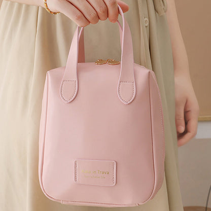 Pink travel bag with double handles, front logo patch, and stitched side seams