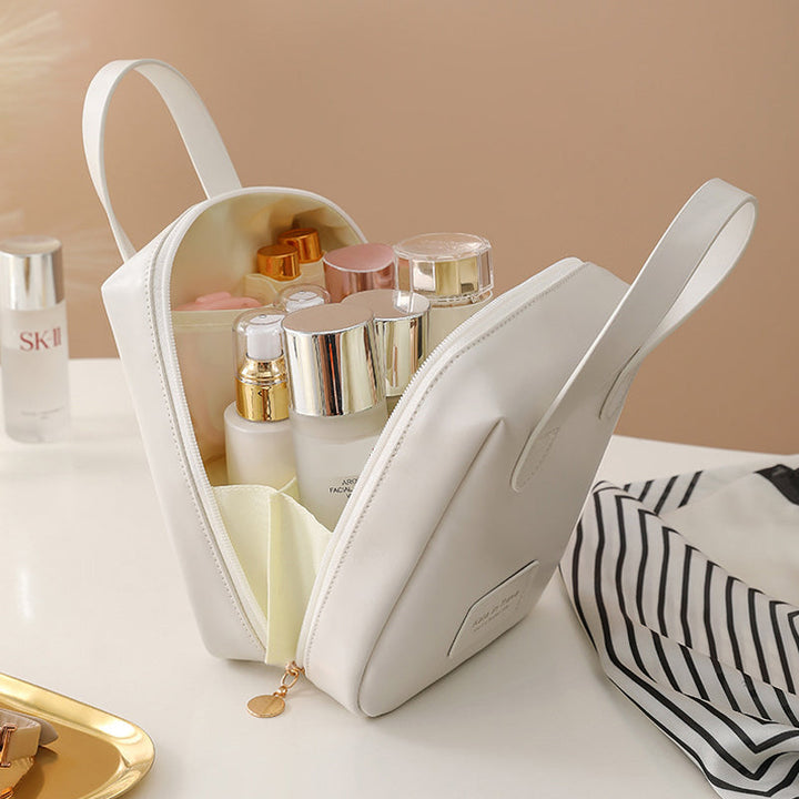 White travel bag opened flat, showing interior compartments with toiletries and bottles