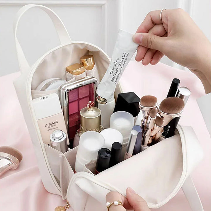 White travel bag open with multiple makeup and skincare items inside