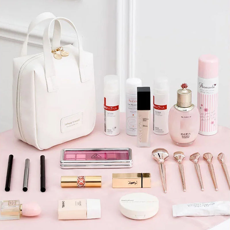 White travel bag tote with top handles, displayed with cosmetics and beauty items