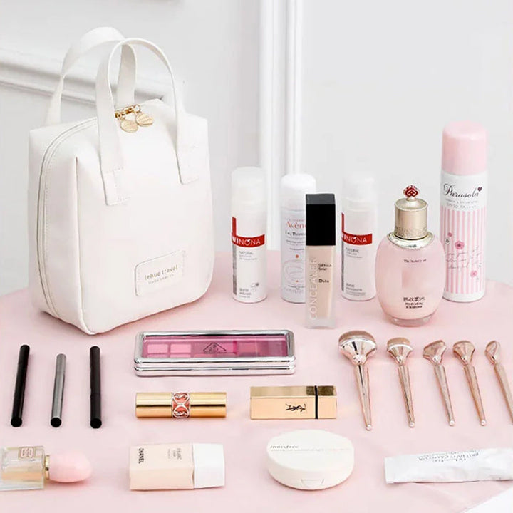 White travel bag tote with top handles, displayed with cosmetics and beauty items