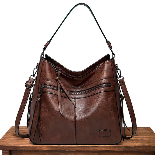 Brown hobo shoulder bag with front zip pockets, tassel detail, and top handle straps