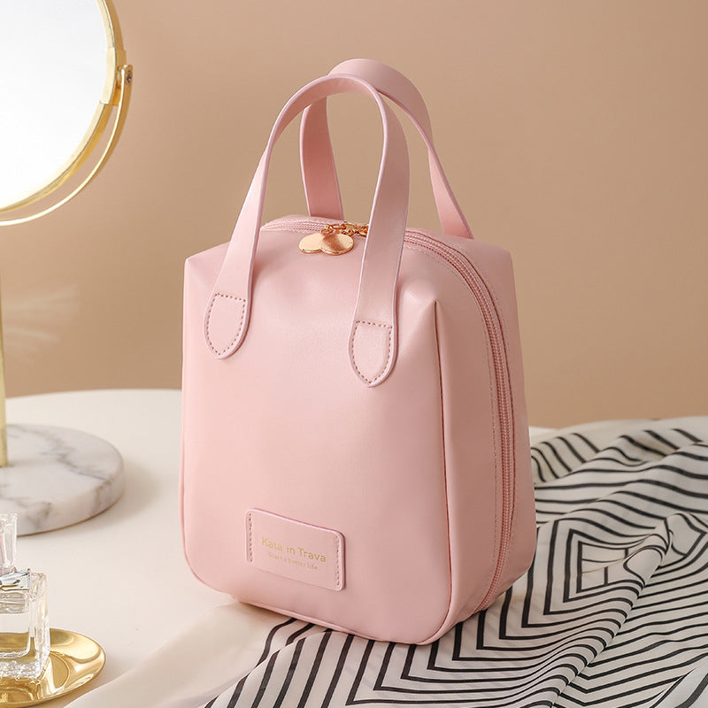 Pink travel bag tote with top handles, gold charm, and front label pocket