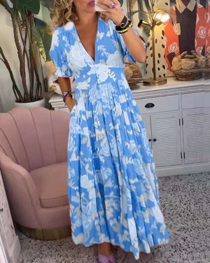 Blue floral maxi dress with white blossoms, V-neck and tiered skirt, short puff sleeves