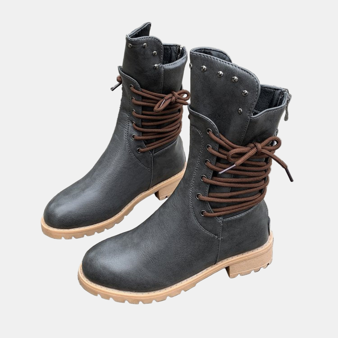 Dark gray mid-length lace-up walking boots with metal studs, brown laces, and chunky sole
