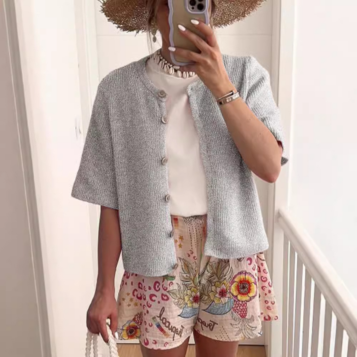Gray short-sleeve button-front knit cardigan with ribbed texture and rounded collar.