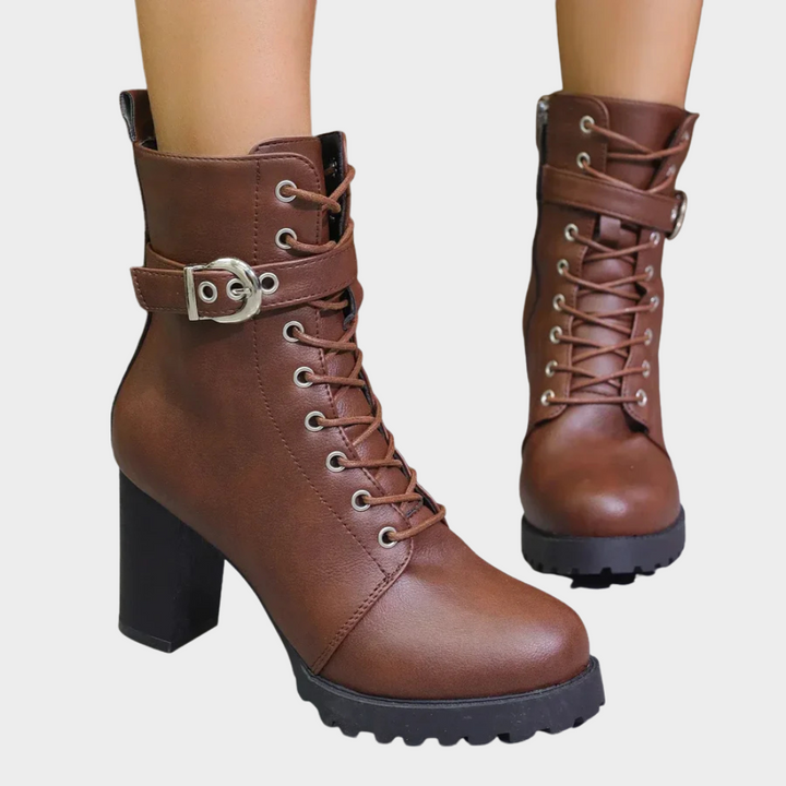 Brown flared heel ankle boots with lace-up front, buckle strap, and chunky tread sole